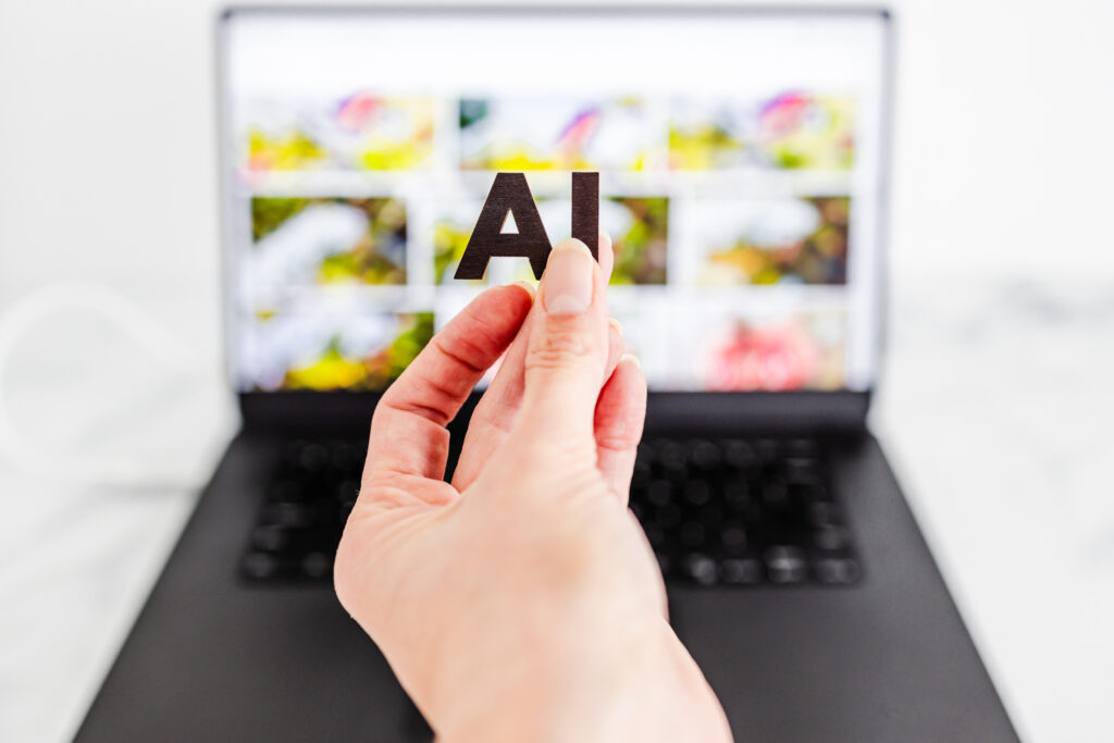 AI text in front of laptop bokeh with out of focus images, concept of Artificial Intelligence creating generative content based on art made by human authors