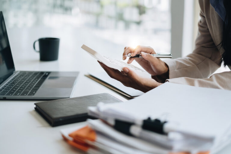 Asian Business Woman or Accountant do math and analyze with calculator and paperwork on desk, account, audit and saving concept